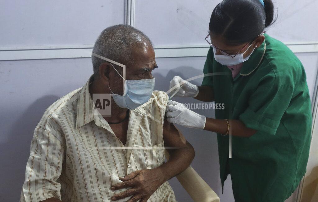 Rafiq Maqbool A health worker administers the COVISHIELD vaccine for COVID-19 at a vaccination center in Mumbai, India, Sunday, April 18, 2021. Over 200,000 new infections were detected in the past 24 hours, and major cities, like Mumbai and New Delhi, are under virus restrictions. (AP Photo/Rafiq Maqbool)