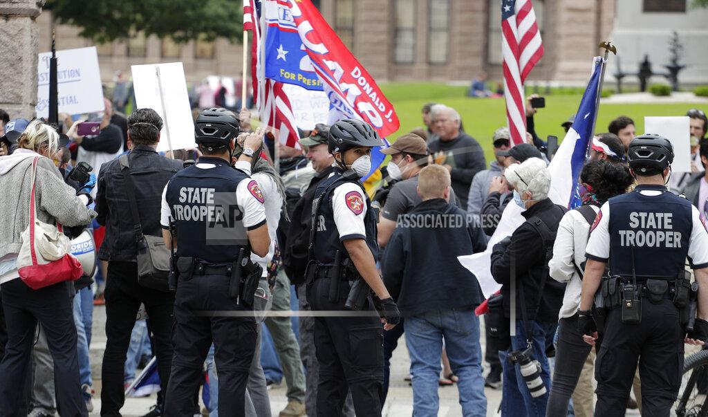 Eric Gay State troopers keep watch as protesters rally at the Texas State Capitol to speak out against Texas' handling of the COVID-19 outbreak, in Austin, Texas, Saturday, April 18, 2020. Austin and many other Texas cities remain under stay-at-home orders due to the COVID-19 outbreak except for essential personal. (AP Photo/Eric Gay)