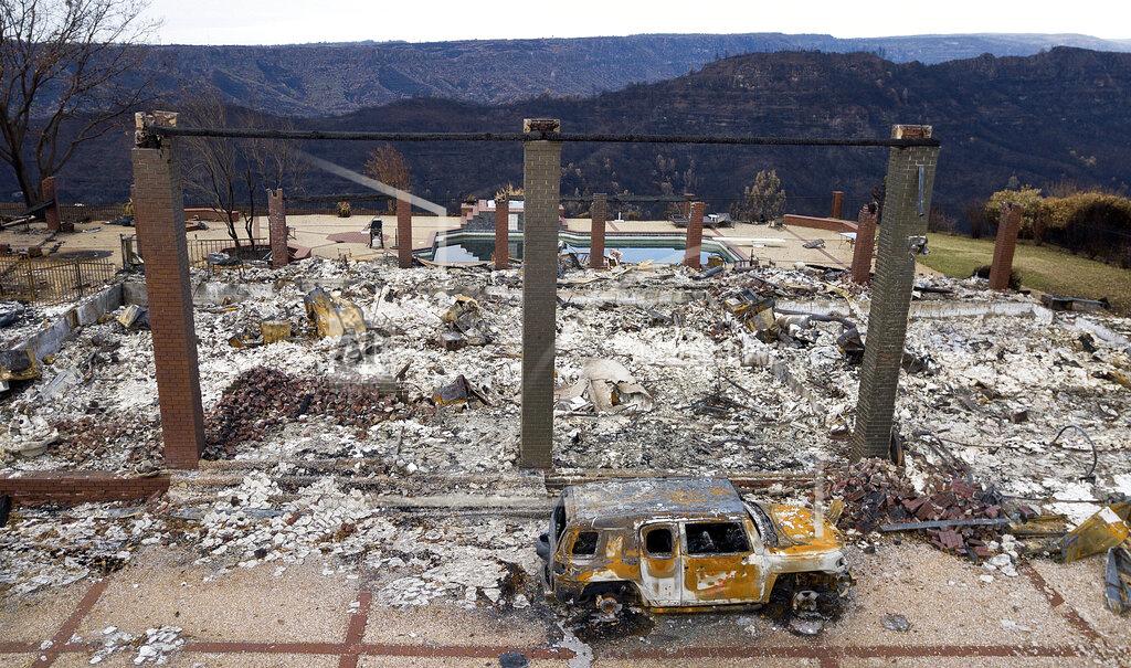 Noah Berger FILE - In this Dec. 3, 2018, file photo, a vehicle rests in front of a home leveled by the Camp Fire in Paradise, Calif. Homeowners and renters in 22 northern California counties are guaranteed not to lose their property insurance policies over the next year after the state announced a moratorium on Monday, Sept. 20, 2021, for people who live near recent wildfires. Insurance Commissioner Ricardo Lara issued a temporary moratorium for about 325,000 policyholders who live near those wildfires. (AP Photo/Noah Berger, File)