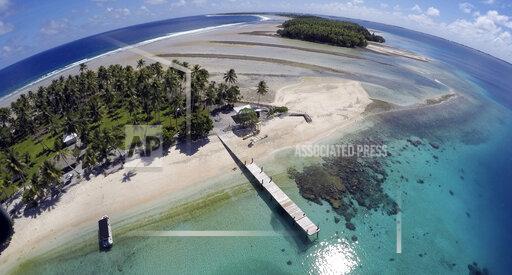 FILE - An aerial photo shows a small section of the atoll that has slipped beneath the water line only showing a small pile of rocks at low tide on Majuro Atoll in the Marshall Islands on Nov. 8, 2015. For decades, the tiny Marshall Islands has been a stalwart American ally. Its location in the middle of the Pacific Ocean has made it a key strategic outpost for the U.S. military. (AP Photo/Rob Griffith, File)