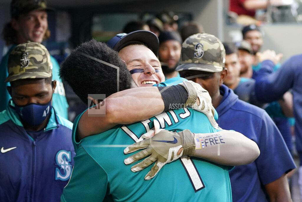 Elaine Thompson Seattle Mariners' Jarred Kelenic, center right, is embraced by Kyle Lewis (1) after hitting a two-run home run against the Cleveland Indians in the third inning of a baseball game Friday, May 14, 2021, in Seattle. (AP Photo/Elaine Thompson)