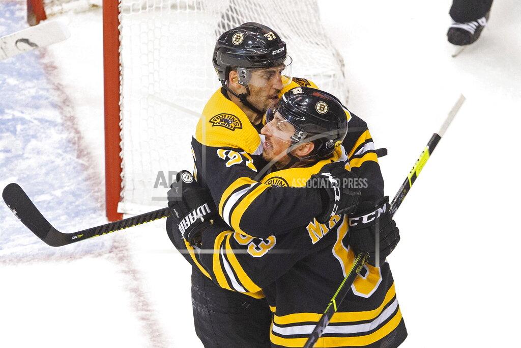 Chris Young Boston Bruins' Brad Marchand (63) celebrates his goal against the Carolina Hurricanes with teammate Patrice Bergeron (37) during the second period of an NHL Eastern Conference Stanley Cup hockey playoff game in Toronto, Thursday, Aug. 13, 2020. (Chris Young/The Canadian Press via AP)