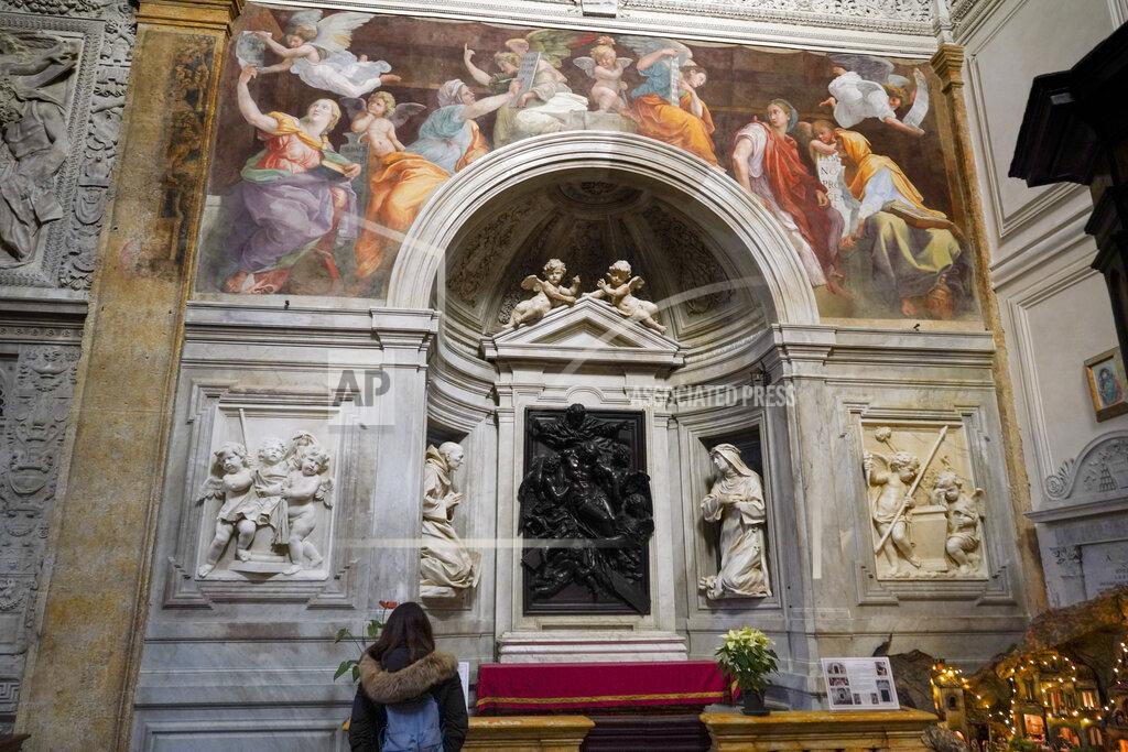 Andrew Medichini A woman admires the 1514 fresco "Sybils receiving instruction from Angels" by Italian High Renaissance master painter Raffaello Sanzio, known as Raphael, adorns the inside of Santa Maria della Pace church, in Rome, Monday, Dec. 14, 2020. Like elsewhere in Europe, museums and art galleries in Italy were closed this fall to contain the spread of COVID-19, meaning art lovers must rely on virtual tours to catch a glimpse of the treasures held by famous institutions such as the Uffizi in Florence and the Vatican Museums in Rome. However, some exquisite gems of Italy's cultural heritage remain on display in real life inside the country's churches, some of which have collections of renaissance art and iconography that would be the envy of any museum. (AP Photo/Andrew Medichini)