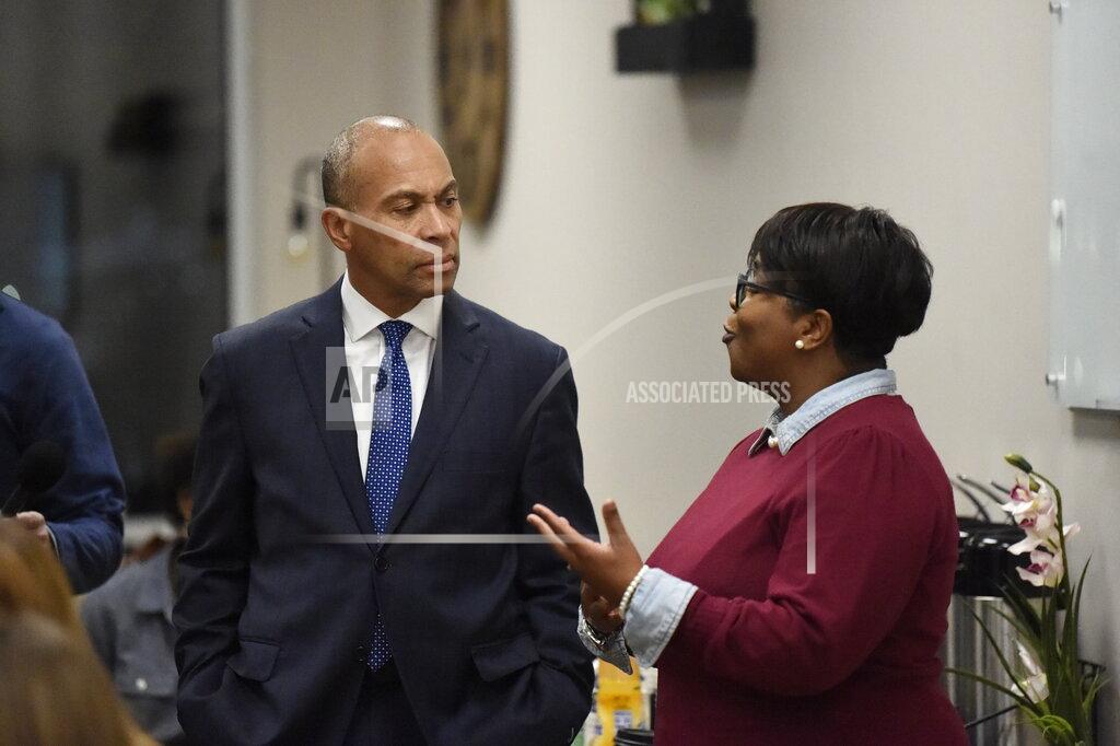 Former Massachusetts Gov. Deval Patrick, left, speaks with a business owner during a campaign stop, Tuesday, Nov. 19, 2019, in Columbia, S.C. (AP Photo/Meg Kinnard)