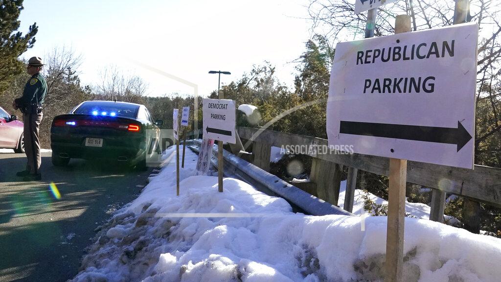 Charles Krupa A sign directs Republican and Democrat legislators to their parking areas as a N.H. State Trooper watches the flow of traffic prior to a New Hampshire House of Representatives session held at NH Sportsplex, due to the coronavirus, Wednesday, Feb. 24, 2021, in Bedford, N.H. (AP Photo/Charles Krupa)