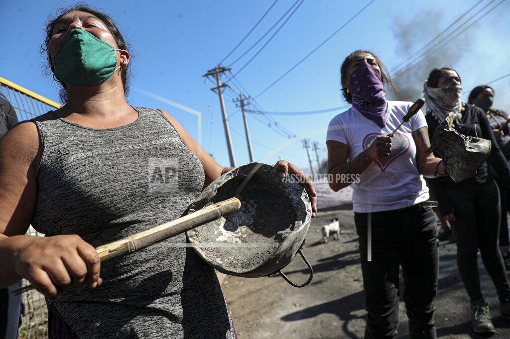 Esteban Felix Demonstrators gather near a burning barricade during a protest demanding food aid from the government amid the new coronavirus pandemic, at the 17 de Mayo neighborhood in Santiago, Chile, Tuesday, May 26, 2020. Many of the hungry in the region are informal workers who make up a sizable portion of Latin America's workforce, while others are newly poor who have lost jobs amidst an historic economic downturn. (AP Photo/Esteban Felix)
