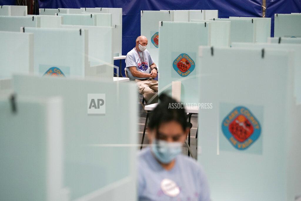 FILE - In this June 9, 2020, file photo, election workers staff one of a few in-person voting places in Las Vegas during a nearly all-mail primary election. Less than eight weeks before Nov. 3 elections, President Donald Trump's campaign is urging a federal judge in Las Vegas to block a new state law and prevent mail-in ballots from going to all active Nevada voters amid the coronavirus pandemic. (AP Photo/John Locher, File)