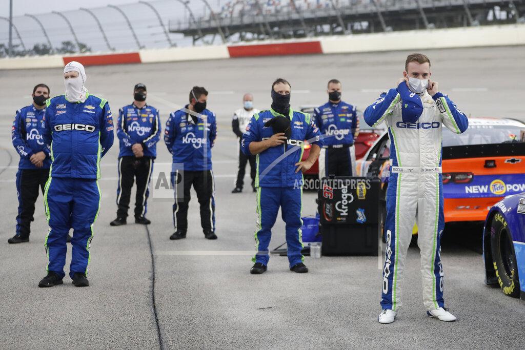 Brynn Anderson CORRECTS THE STATE TO S.C. - Driver Ty Dillon, right, stands for the national anthem before the start of the Toyota 500 NASCAR Cup Series auto race Wednesday, May 20, 2020, in Darlington, S.C. (AP Photo/Brynn Anderson)