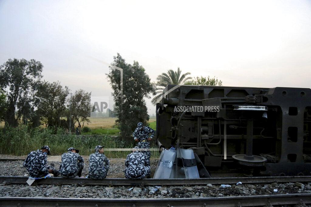 Fadel Dawood Egyptian security forces prepare to break their fast during the holy month of Ramadan, at the site of a passenger train that derailed injuring around 100 people, near Banha, Qalyubia province, Egypt, Sunday, April 18, 2021. The train was travelling to the Nile Delta city of Mansoura from the Egyptian capital, the statement said. (AP Photo/Fadel Dawood)