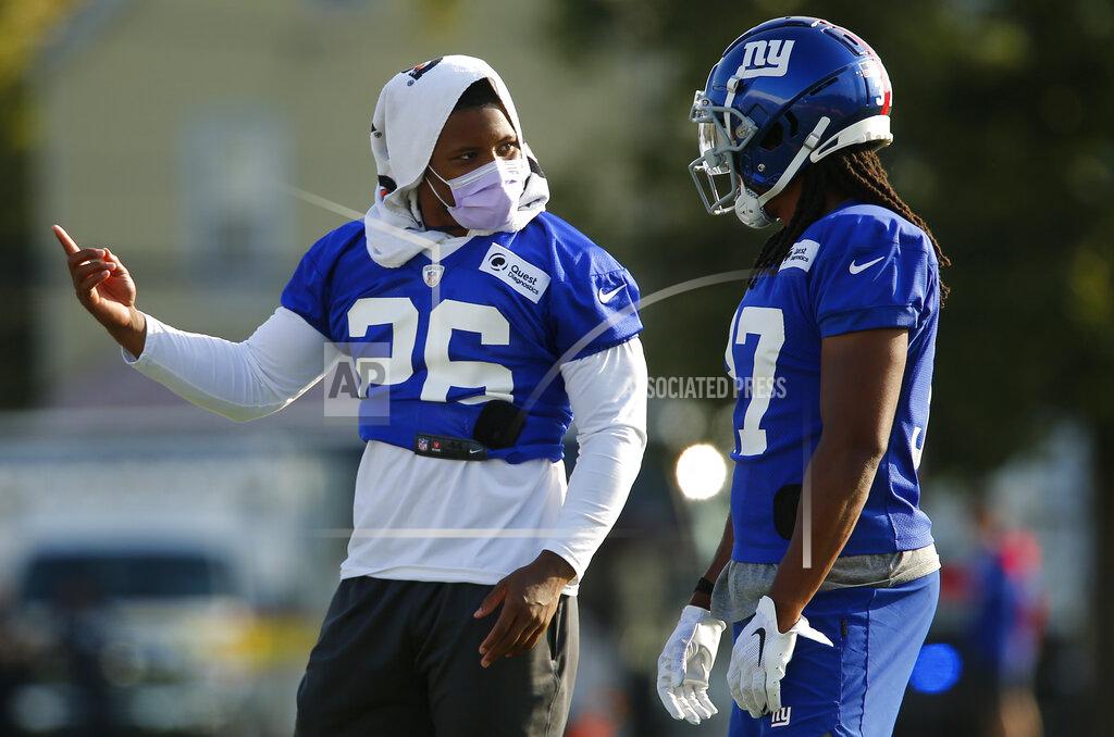 John Munson Saquon Barkley, left, who is on the physically unable to perform list, talks with fellow running back Gary Brightwell during the New York Giants' NFL football training camp practice at Eddie Moraes Stadium, Saturday, July 31, 2021, in Newark, N.J. (AP Photo/John Munson)