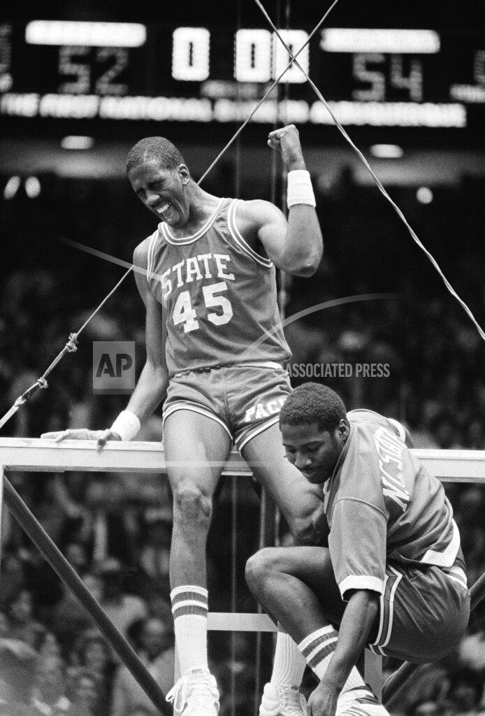 Anonymous FILE - In this early Tuesday, April 5, 1983, file photo, North Carolina center Cozell McQueen (45) yells while standing on the rim after defeating Houston 54-52 to win the NCAA college basketball championship in Albuquerque, N.M. Joining McQueen on the rim is teammate Ernie Myers. There are still moments, even after nearly four decades, when Ernie Myers has trouble believing it all really happened for his North Carolina State team. (AP Photo/File)