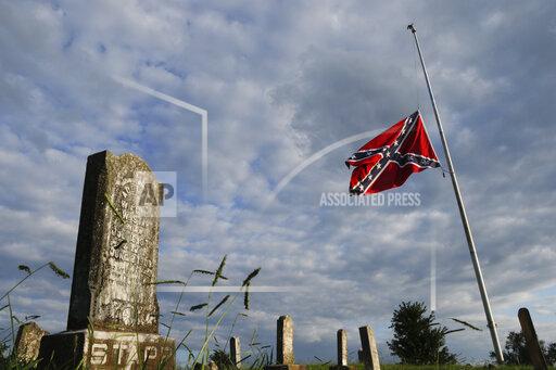 FILE- A confederate flag flies at half staff at Nathan Anderson Cemetery on Tuesday, Aug. 21, 2018, in Ringgold, Ga. A federal appeals court ruled Tuesday, Sept. 28, 2021, that the Georgia city of Alpharetta, an Atlanta suburb, did not violate the constitutional rights of a Sons of Confederate Veterans group when it banned the Confederate battle flag from its annual parade honoring veterans of American wars. (Doug Strickland/Chattanooga Times Free Press via AP, File)