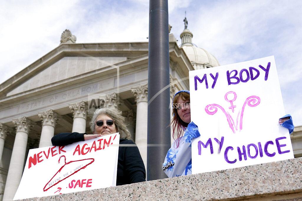Sue Ogrocki FILE - Dani Thayer, left, and Marina Lanae, right, both of Tulsa, Okla., hold pro-choice signs at the state Capitol, Wednesday, April 13, 2022, in Oklahoma City. Oklahoma Gov. Kevin Stitt on Wednesday, May 25 signed into law the nation’s strictest abortion ban, making the state the first in the nation to effectively end availability of the procedure. State lawmakers approved the ban enforced by civil lawsuits rather than criminal prosecution, similar to a Texas law that was passed last year. (AP Photo/Sue Ogrocki File)