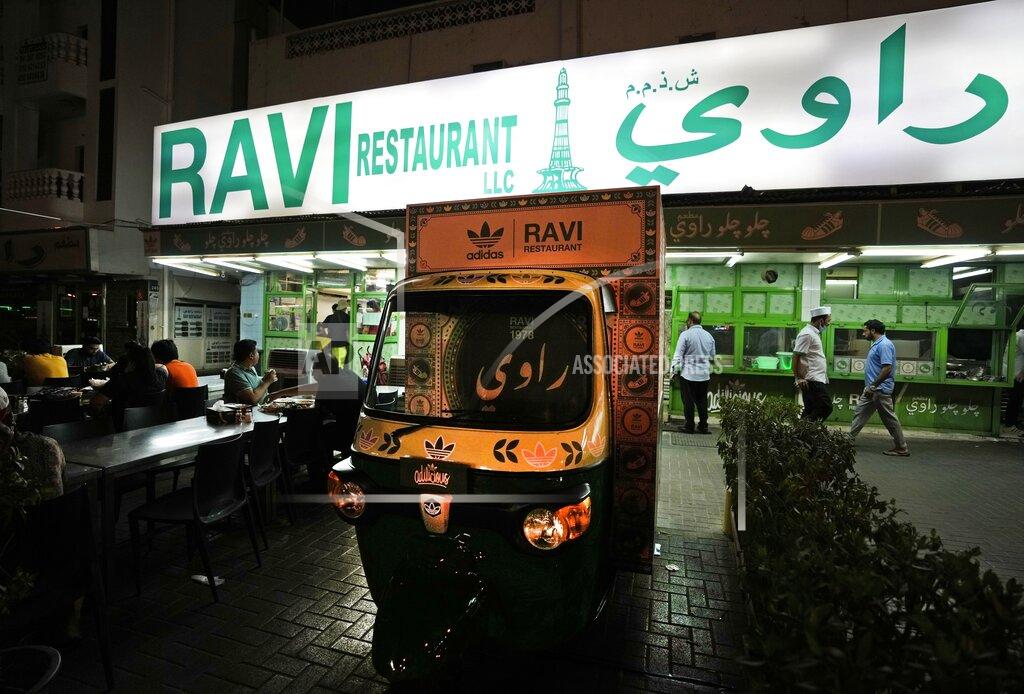 Kamran Jebreili People dine out next to Ravi X Adidas truck in front of the Ravi restaurant in Satwa district of Dubai, United Arab Emirates, Wednesday, June 22, 2022. Adidas has teamed up with Dubai nostalgic family-owned Pakistani restaurant to release the Superstar Ravi sneaker. (AP Photo/Kamran Jebreili)