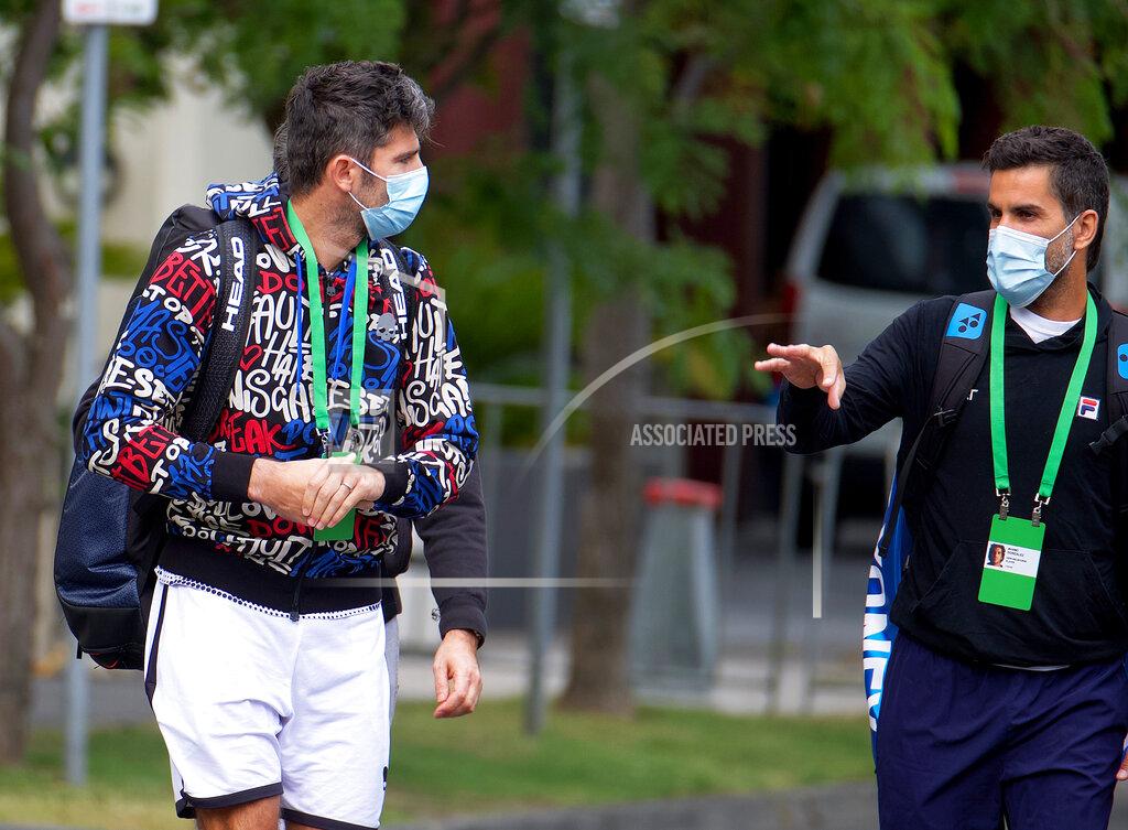 Luis Ascui Italian tennis player Simone Bolelli, left, and Argentina's Maximo Gonzalez are escorted to their training session in Melbourne, Australia, Monday, Jan. 18, 2021. The number of players in hard quarantine swelled to 72 ahead of the Australian Open after a fifth positive coronavirus test was returned from the charter flights bringing players, coaches, officials and media to Melbourne for the season-opening tennis major. (Luis Ascui/AAP Image via AP)