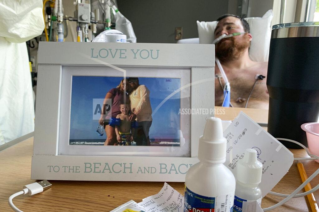 Sarah Blake Morgan A framed photo of his family sits in front of Daryl Barker as he slowly recovers from COVID-19 inside Lake Regional Hospital's ICU in Osage Beach, Mo., on Monday, July 26, 20021. Barker had chosen not to be vaccinated against the virus but his long hospitalization has forced him to reconsider. (AP Photo/Sarah Blake Morgan)