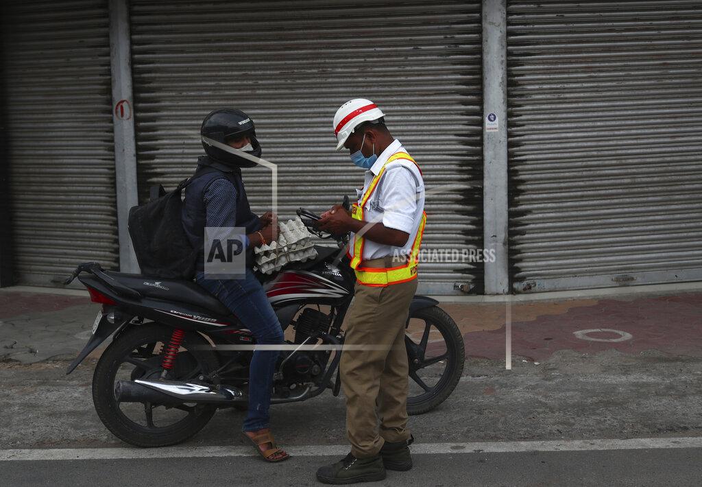 Mahesh Kumar A A traffic policemen gives a penalty to a motorist for breaking COVID-19 guidelines during a lockdown imposed to curb the spread of the coronavirus in Hyderabad, India, Saturday, June 12, 2021. (AP Photo/Mahesh Kumar A.)