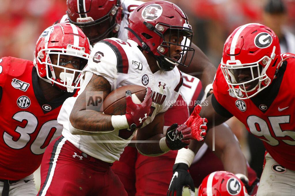 Joshua L. Jones South Carolina running back Rico Dowdle (5) avoids a tackle from Georgia inside linebacker Tae Crowder (30) and Georgia defensive lineman Devonte Wyatt (95) in overtime of a NCAA football game between Georgia and South Carolina in Athens, Ga., on Saturday, Oct. 12, 2019. South Carolina won 20-17 in double overtime. (Joshua L. Jones/Athens Banner-Herald via AP)