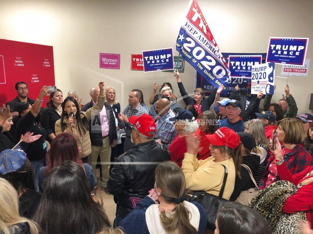 Morgan Lee Anti-abortion activist Elisa Martinez, with microphone, urges voters to support President Donald Trump at a political rally in support of President Donald Trump and allied political candidates in Albuquerque, N.M., on Wednesday, Sept. 9, 2020. Republican candidates and party officials are touring the state by bus to court female voters. Martinez remains politically active after losing the GOP nomination in an open U.S. Senate race to Mark Ronchetti of Albuquerque in June. Democratic Party Chairwoman Marg Elliston said the rallies are risking lives as large groups gather largely without masks in defiance of a public health order that requires masks in public and limits gatherings to 10 people. (AP Photo/Morgan Lee)