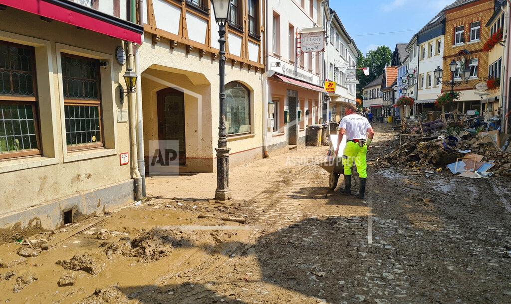 Frank Jordans A man uses a wheelbarrow to move debris through the streets of the flood hit town of Ahrweiler, Germany, on Friday, July 23, 2021. With the death toll and economic damage from last week’s floods in Germany continuing to rise, questions have been raised about why systems designed to warn people of the impending disaster didn’t work. (AP Photo/Frank Jordans)