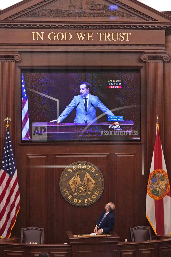 Wilfredo Lee Florida Senate President Wilton Simpson, bottom, looks up as he watches Florida Speaker of the House Chris Sprowls on a large television screen near the end of a legislative session, Friday, April 30, 2021, at the Capitol in Tallahassee, Fla. (AP Photo/Wilfredo Lee)