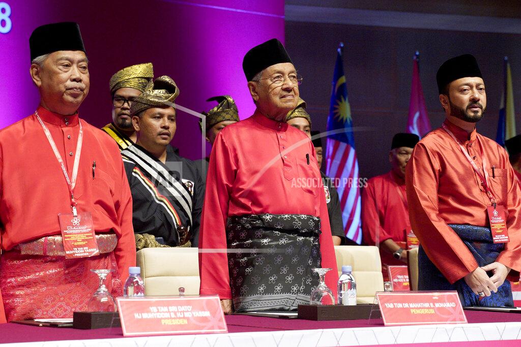 Yam G-Jun FILE- In this Dec. 29, 2018, file photo, Malaysian Prime Minster Mahathir Mohamad, center, stands next to his son Malaysian United Indigenous Party Vice President Mukhriz Mahathir, right, and President Muhyiddin Yassin, left, during the Malaysian United Indigenous Party general assembly at Putrajaya International Convention Centre in Putrajaya, Malaysia. Former Prime Minister Mahathir has been ousted from his Malay party in the latest twist to a power struggle with his successor Muhyiddin Yassin, but he has vowed to challenge the move. The 94-year-old Mahathir, along with his son and three other senior members, were expelled from the Bersatu party on Thursday, May 28, 2020. (AP Photo/Yam G-Jun, File)