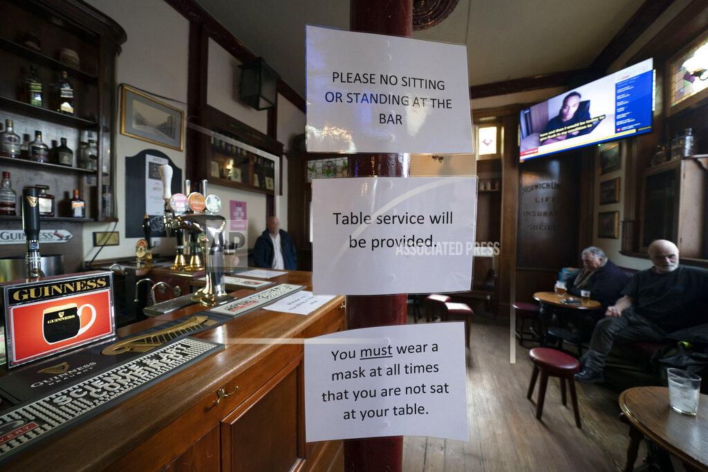 Jon Super Signage showing anti-coronavirus guidance measures is displayed in the Dispensary pub in Liverpool, England, Monday Oct 12, 2020. As the first area in England slapped with strict new restrictions to curb the resurgent coronavirus that have shuttered pubs and imperiled thousands of jobs, Liverpool again feels it's being punished by policies made in Britain's capital, 180 miles (290 kilometers) to the south. (AP Photo/Jon Super)