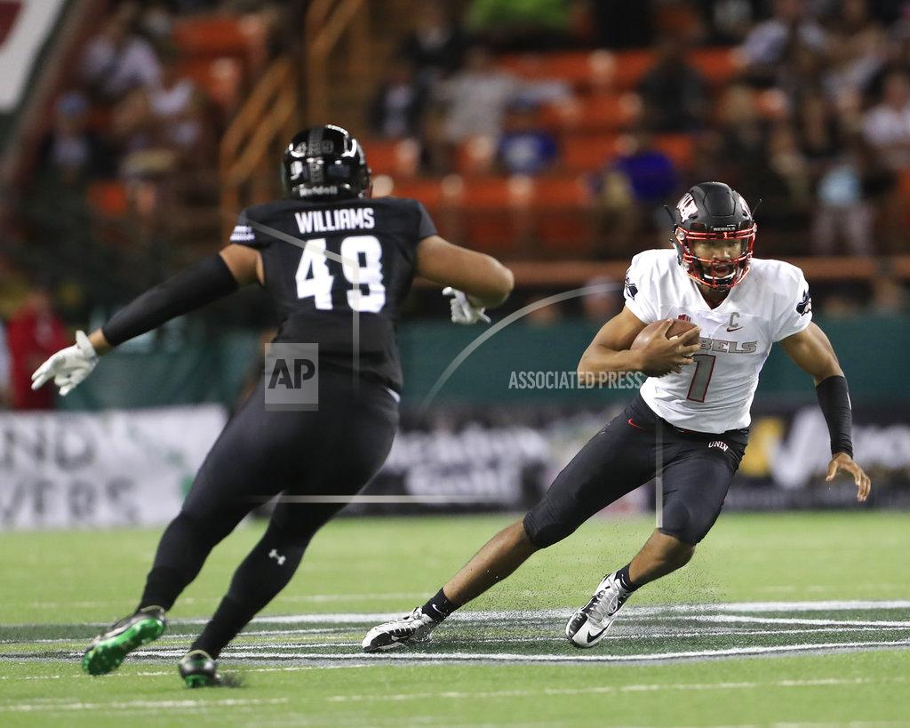 Marco Garcia UNLV quarterback Armani Rogers (1) slides away from Hawaii defensive lineman Manly Williams (49) during the second quarter of an NCAA college football game, Saturday, Nov. 17, 2018, in Honolulu. (AP Photo/Marco Garcia)