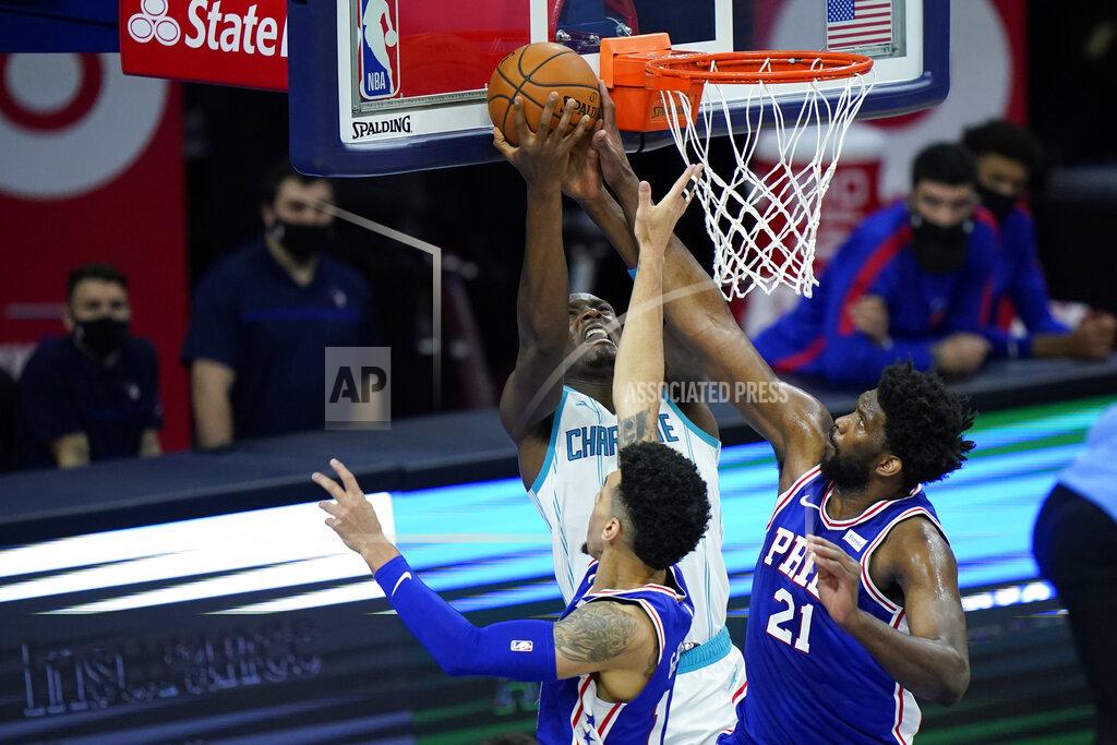 Matt Slocum Charlotte Hornets' Bismack Biyombo, left, goes up for a shot against Philadelphia 76ers' Joel Embiid, right, and Danny Green during the second half of an NBA basketball game, Monday, Jan. 4, 2021, in Philadelphia. (AP Photo/Matt Slocum)