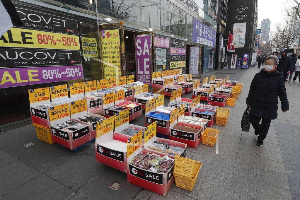 Ahn Young-Joon A woman wearing a face mask walks by a merchandise store in Seoul, South Korea, Thursday, March 4, 2021. South Korea's central bank says the country's economy shrank for the first time in 22 years in 2020 as the coronavirus pandemic destroyed service industry jobs and depressed consumer spending. (AP Photo/Ahn Young-joon)