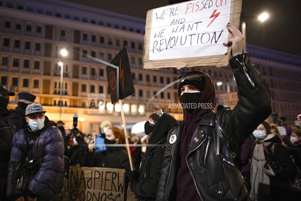 People take part in a protest against a top court ruling restricting abortions in Warsaw, Poland, Wednesday, Nov. 18, 2020. Polish police came under criticism on Thursday for using tear gas and force on mostly female and young protesters during the latest in a string of women-led protests against a top court ruling restricting abortion.(AP Photo/Agata Grzybowska)