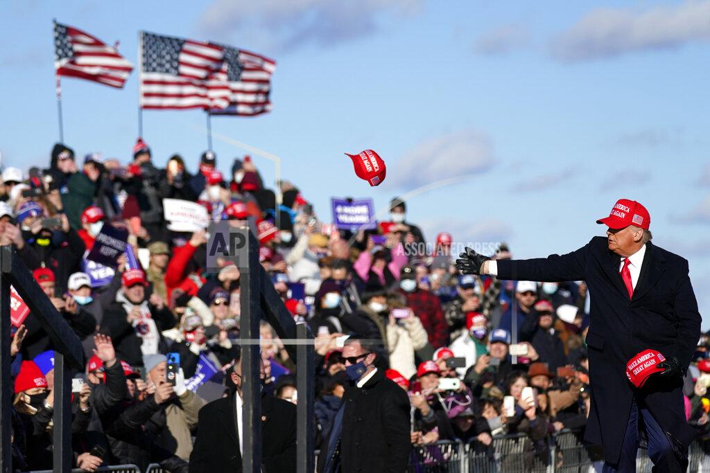 Evan Vucci President Donald Trump throws hats to supporters as he arrive to speak during a campaign rally at Wilkes-Barre Scranton International Airport, Monday, Nov. 2, 2020, in Avoca, Pa. (AP Photo/Evan Vucci)