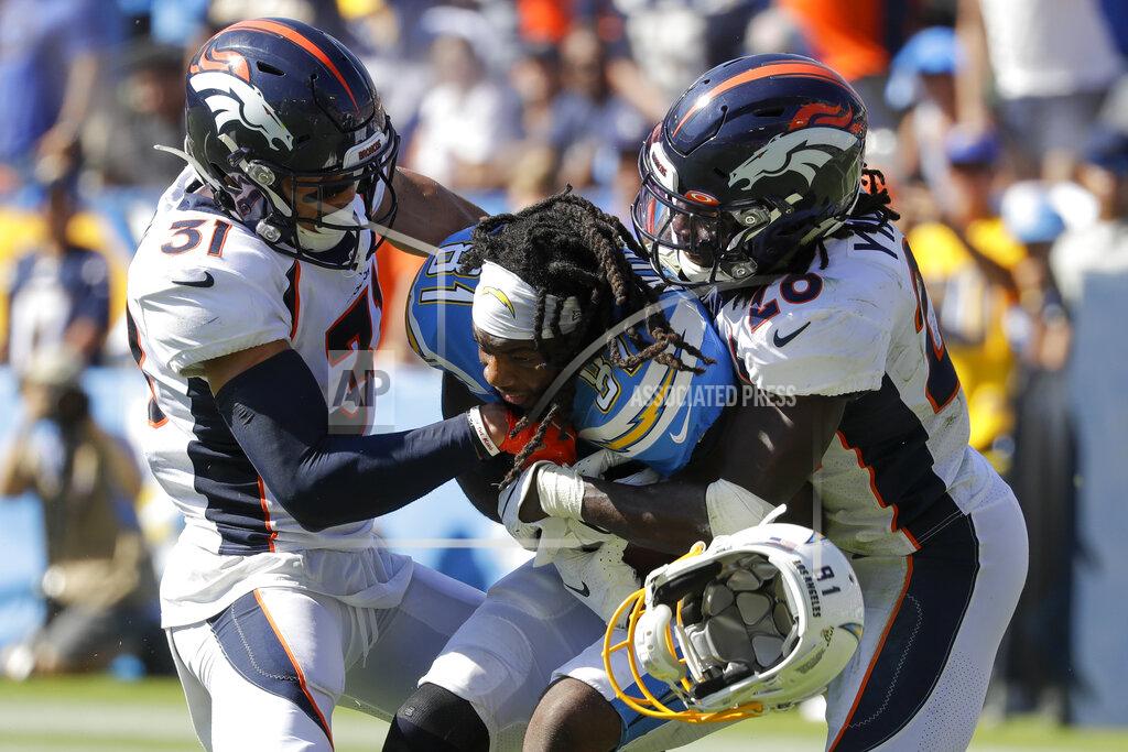 Alex Gallardo Denver Broncos free safety Justin Simmons, left, and cornerback Isaac Yiadom, right, tackle Los Angeles Chargers wide receiver Mike Williams as he looses his helmet during the first half of an NFL football game Sunday, Oct. 6, 2019, in Carson, Calif. (AP Photo/Alex Gallardo)