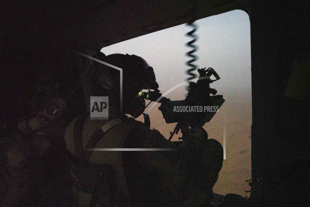 Uncredited A French Barkhane force soldiers mans a machine gun on board a Caiman transport helicopter during a night mission in Gao, Mali, Monday June 7, 2021. France has suspended joint military operations with Malian forces until the junta led by Col. Assimi Goita, who retook control of Mali's transitional government May 24, complies with international demands to restore civilian rule. (AP Photo/Jerome Delay)