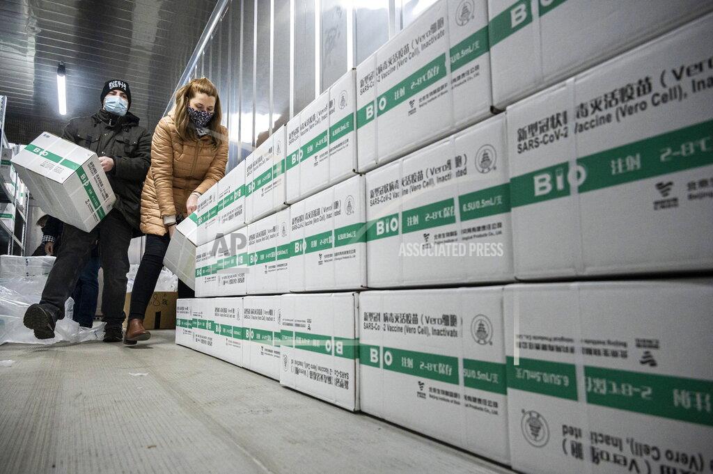 Zsolt Szigetvary Employees unload the newly arrived coronavirus vaccines from Chinese pharmaceutical company Sinopharm at the logistics base set up to in the parking lot of the government office in the 13th district of Budapest, Hungary, March 3, 2021. (Zsolt Szigetvary/MTI via AP)