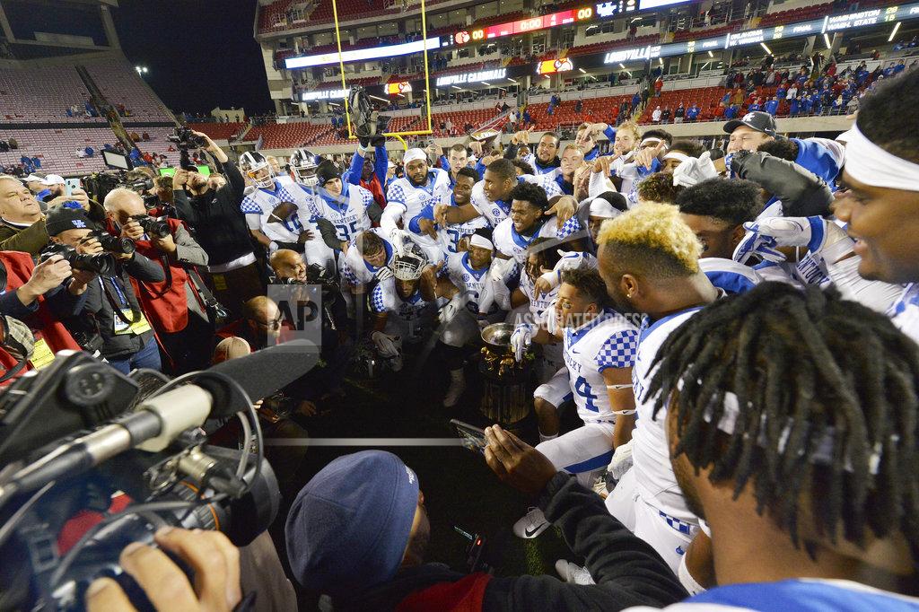 Timothy D. Easley Kentucky team members pose in front of the Governor's Cup following their 56-10 victory over Louisville in an NCAA college football game, in Louisville, Ky., Saturday, Nov. 24, 2018. (AP Photo/Timothy D. Easley)