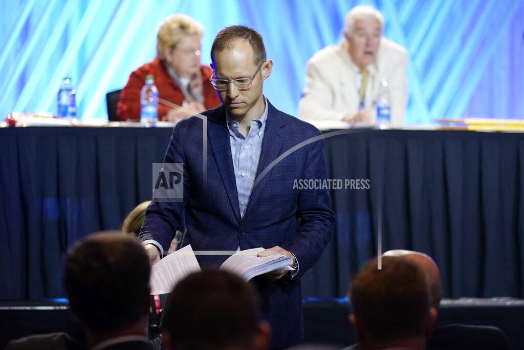 Mark Humphrey Dr. Jared Wellman, pastor at Tate Springs Baptist Church in Arlington, Texas, hands out copies of his motion during the executive committee plenary session at the denomination's annual meeting Monday, June 14, 2021, in Nashville, Tenn. Wellman's motion called for an independent committee to lead a probe of the denomination's handling of sex abuse cases. (AP Photo/Mark Humphrey)