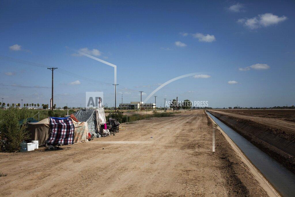 This July 24, 2020, photo shows a homeless encampment near a canal in El Centro, Calif. As support services have dwindled amid the COVID-19 pandemic, some homeless people in Imperial County have resorted to bathing in irrigation canals. Homelessness looks different in different parts of the U.S., especially in rural agricultural regions such as Imperial County. (Anna Maria Barry-Jester/KHN and the Howard Center For Investigative Journalism via AP)