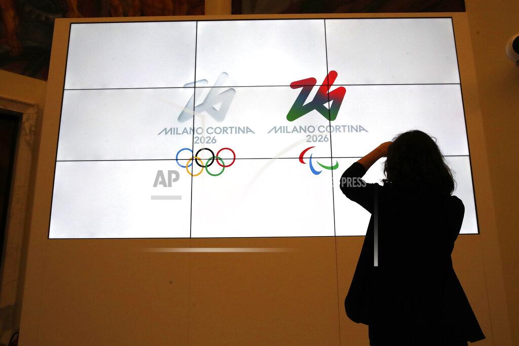 Alessandra Tarantino The logo of 2026 Milan-Cortina Olympics and Paralympics, right, are unveiled to the journalists at a press conference in Rome, Tuesday, March 30, 2021. A futuristic white-on-white logo was unveiled as the emblem for the 2026 Milan-Cortina Olympics on Tuesday following an online vote. Nearly a million votes were cast, 871,566 to be exact, over the last two weeks from Italy and 168 other nations for the two finalists. The “Futura” logo received 75 percent of the votes, winning easily ahead of the more traditional “Dado” option. (AP Photo/Alessandra Tarantino)