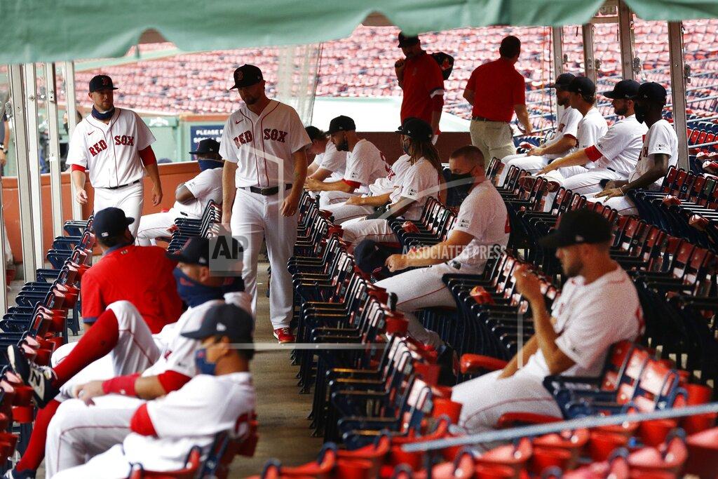 Michael Dwyer Boston Red Sox players practice social distancing in an expanded dugout during the first inning of an opening day baseball game against the Baltimore Orioles at Fenway Park, Friday, July 24, 2020, in Boston. (AP Photo/Michael Dwyer)