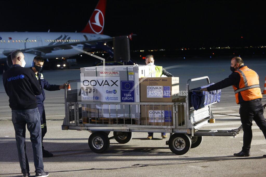 Str FILE - In this Sunday, March 28, 2021 file photo, airport personal unload the first batch of the AstraZeneca vaccines sent from the Covax facility, at Adem Jashari airport Pristina, Kosovo which is the last country in the continent yet to start inoculations. In late June, the international system for sharing coronavirus vaccines sent about 530,000 doses to Britain – more than double the amount sent that month to the entire continent of Africa. It was the latest example of how a system that was supposed to guarantee low and middle-income countries vaccines is failing, leaving them at the mercy of haphazard donations from rich countries. (AP Photo, file)