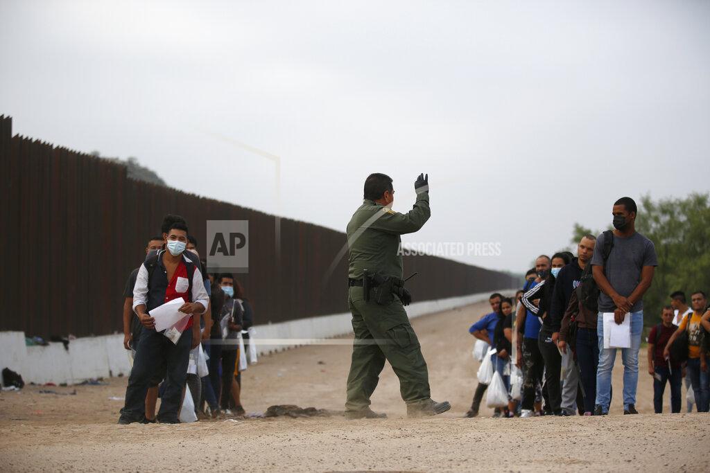 Dario Lopez-Mills A Border Patrol agent instructs migrants who had crossed the Rio Grande river into the U.S. in Eagle Pass, Texas, Friday, May 20, 2022. The Eagle Pass area has become increasingly a popular crossing corridor for migrants, especially those from outside Mexico and Central America, under Title 42 authority, which expels migrants without a chance to seek asylum on grounds of preventing the spread of COVID-19. A judge was expected to rule on a bid by Louisiana and 23 other states to keep Title 42 in effect before the Biden administration was to end it Monday. (AP Photo/Dario Lopez-Mills)