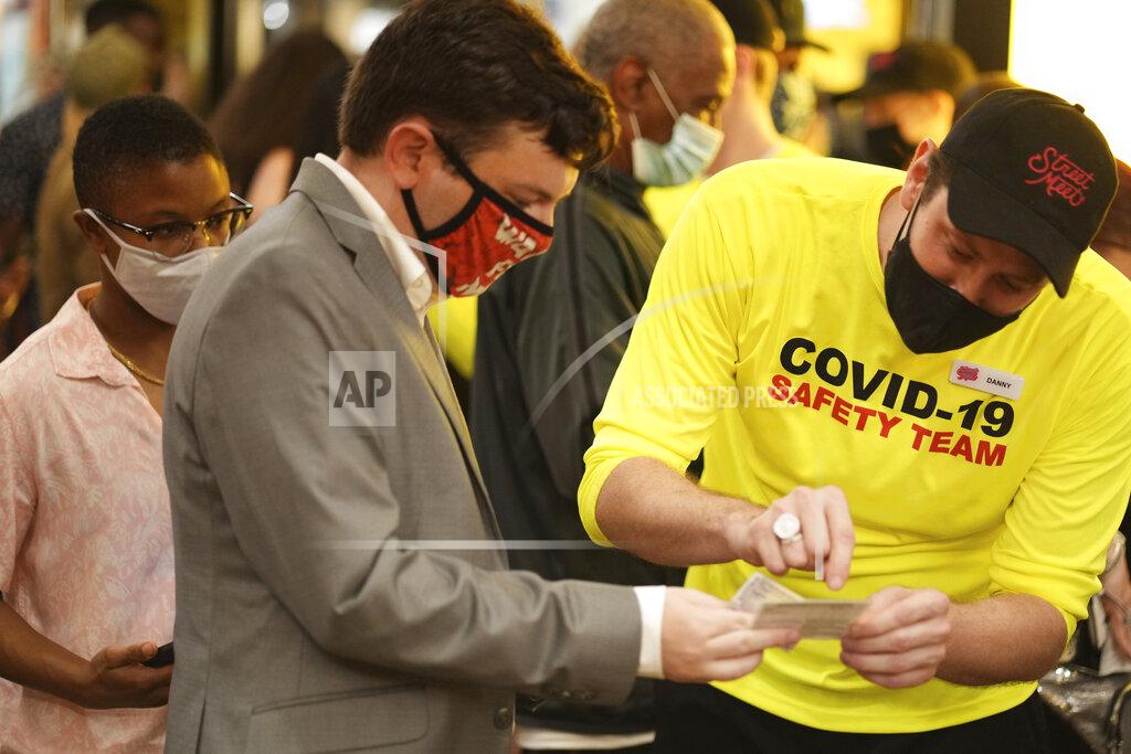 Charles Sykes Theatergoers show proof of vaccination before a performance of "The Lion King," on Broadway, at the Minskoff Theatre, Tuesday, Sept. 14, 2021, in New York. (Photo by Charles Sykes/Invision/AP)