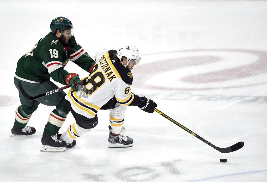 Boston Bruins' David Pastrnak (88), of the Czech Republic, has the puck against Minnesota Wild's Luke Kunin (19) during the first period of an NHL hockey game Saturday, Feb. 1, 2020, in St. Paul, Minn. (AP Photo/Hannah Foslien)