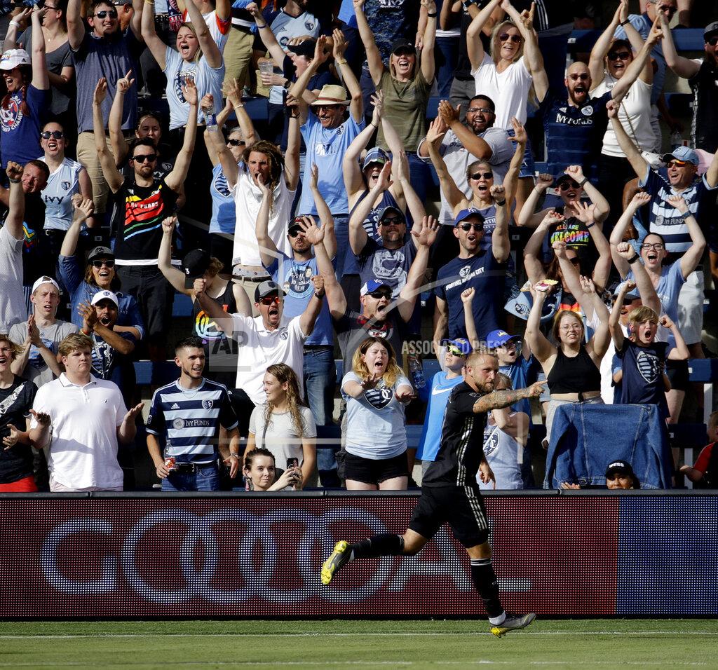 Charlie Riedel FILE - In this May 26, 2019, file photo, Sporting Kansas City forward Johnny Russell celebrates after scoring a goal during the first half of an MLS soccer match against the Seattle Sounders, in Kansas City, Kan. Many professional sports league, such as the NFL and European soccer leagues, have lucrative television contracts and big-money corporate sponsors that fill their substantial coffers. But the domestic soccer league in the U.S. still relies heavily on ticket sales, merchandising and concessions, much like many university athletic departments, and without games their very ability to make ends meet would stretch the abilities of even the savviest of accountants.(AP Photo/Charlie Riedel, File)