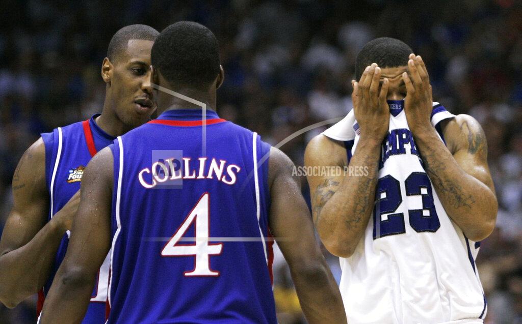 FILE - In this April 7, 2008, file photo, Memphis' Derrick Rose (23) covers his face in front of Kansas' Sherron Collins (4) and Mario Chalmers, left, late in the overtime period of the championship game at the NCAA college basketball Final Four in San Antonio. Kansas won 75-68. (AP Photo/Eric Gay, FIle)