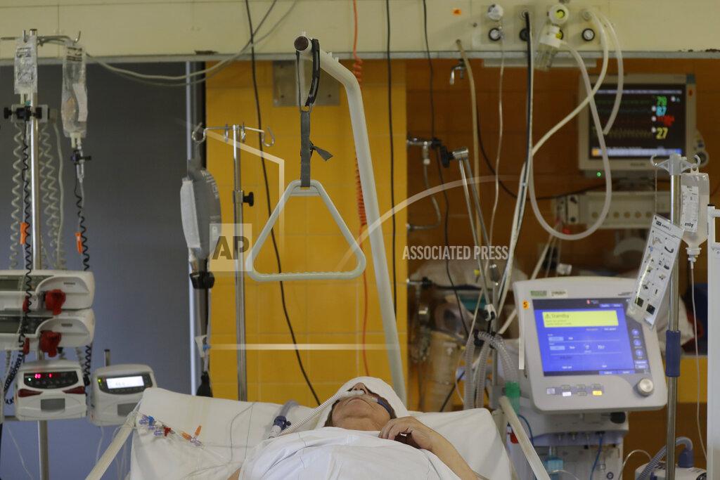 A COVID-19 patient lies on a bed in an intensive care unit (ICU) at Na Bulovce hospital in Prague, Czech Republic, Thursday, Oct. 1, 2020. A record surge of new coronavirus infections in the Czech Republic in September has been followed by a record surge of those hospitalized with COVID-19. The development has started to put the health system in the country under serious pressure for the first time since the pandemic hit Europe. (AP Photo/Petr David Josek)