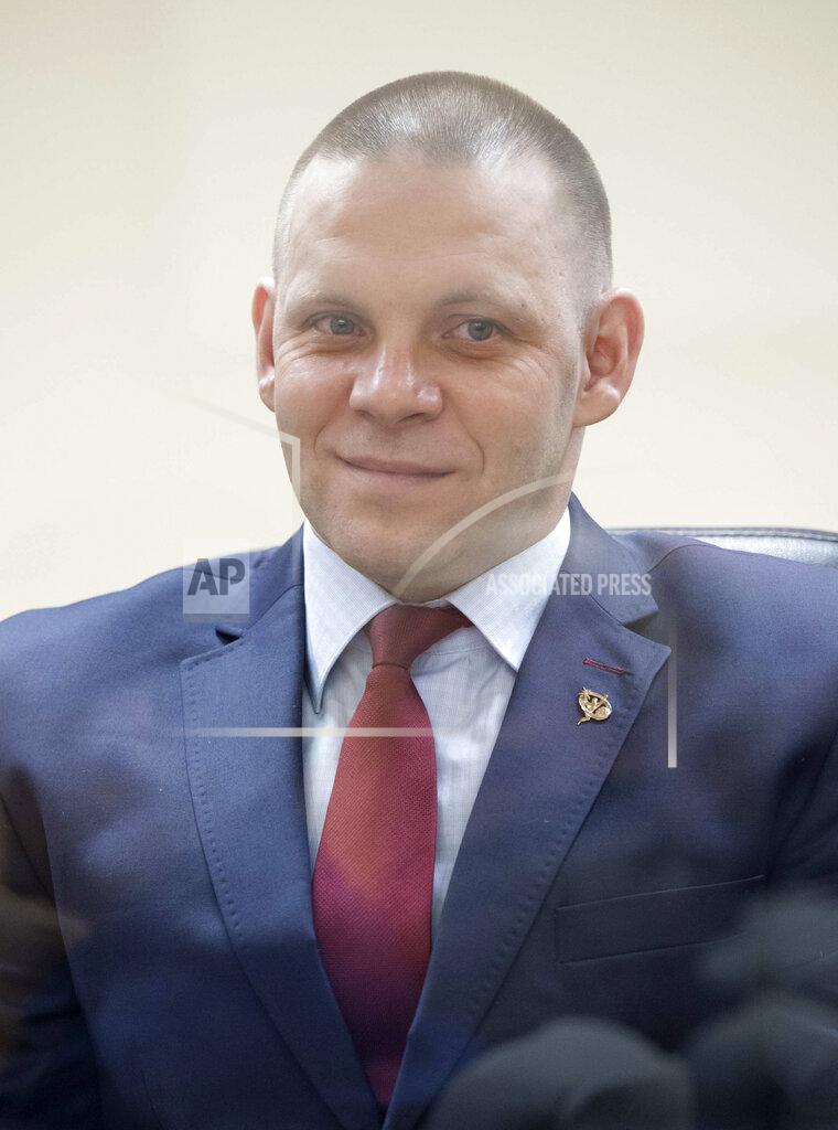 In this handout photo released by Roscosmos Russian cosmonauts Ivan Vagner, member of the main crew to the International Space Station (ISS), seen through glass as he attends a State Committee meeting at the Baikonur Cosmodrome, Kazakhstan, Wednesday, April 8, 2020. The new Soyuz mission to the International Space Station is scheduled on Thursday, April 9. (Roscosmos Space Agency Press Service via AP)