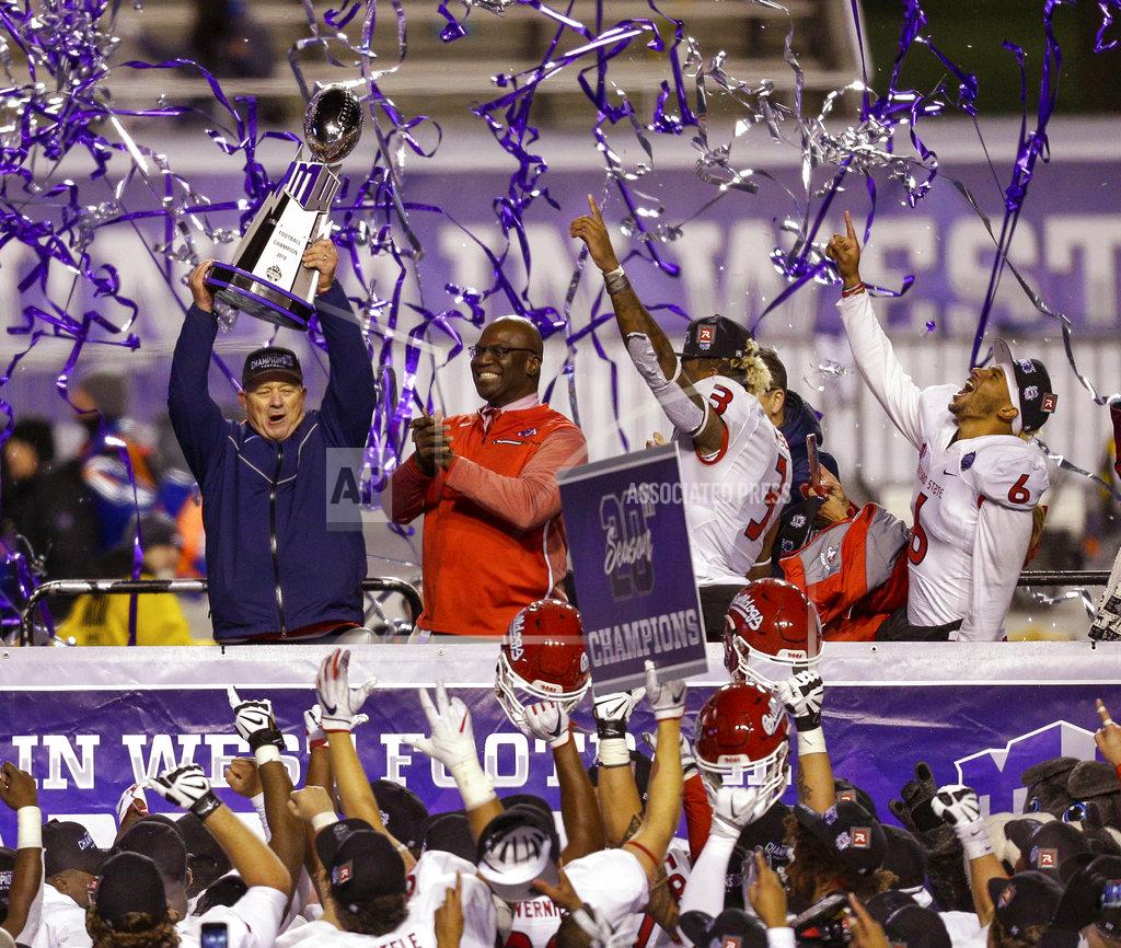 Steve Conner Fresno State coach Jeff Tedford holds up the trophy as defensive end Mykal Walker (3) and quarterback Marcus McMaryion (6) celebrate on stage after an NCAA college football game against Boise State for the Mountain West championship, Saturday, Dec. 1, 2018, in Boise, Idaho. Fresno State won 19-16. (AP Photo/Steve Conner)