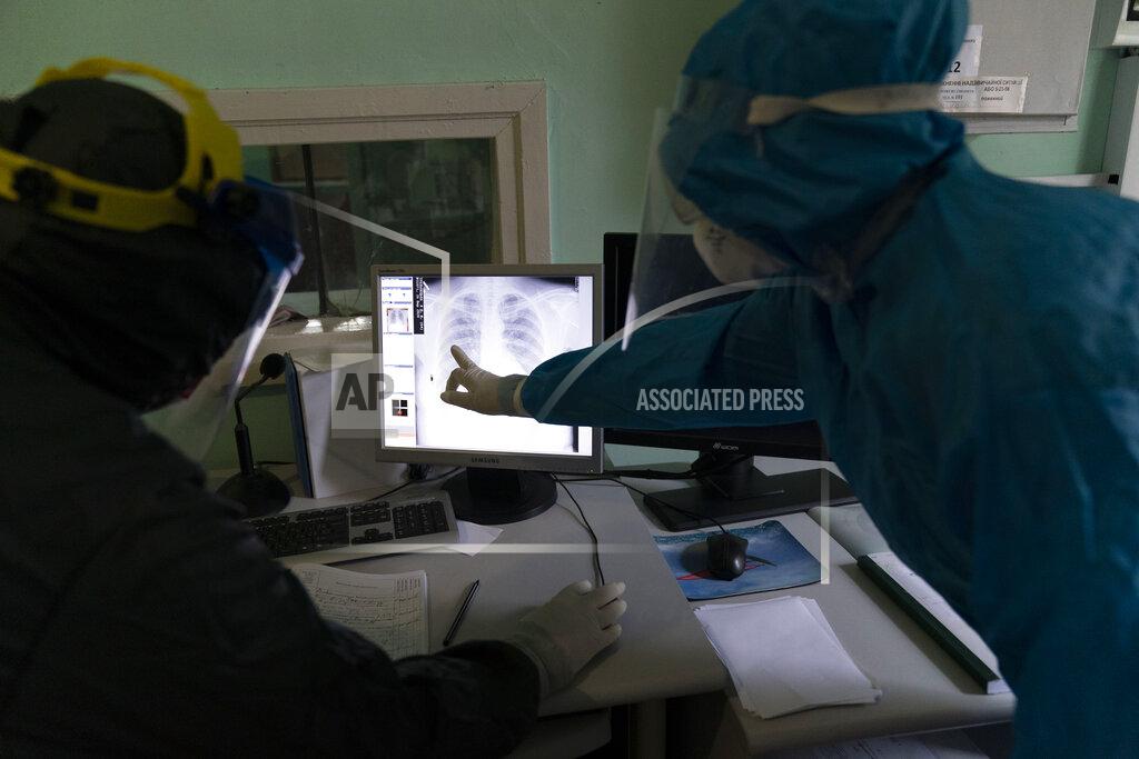 Medical workers look at an X-ray of lungs at a hospital in Stryi, Ukraine, on Tuesday, Sept. 29, 2020. Coronavirus infections in Ukraine began surging in late summer, and the ripples are hitting towns in the western part of the country. The government wants to avoid imposing a new lockdown, but officials acknowledge that the rising infections could make it necessary. (AP Photo/Evgeniy Maloletka)